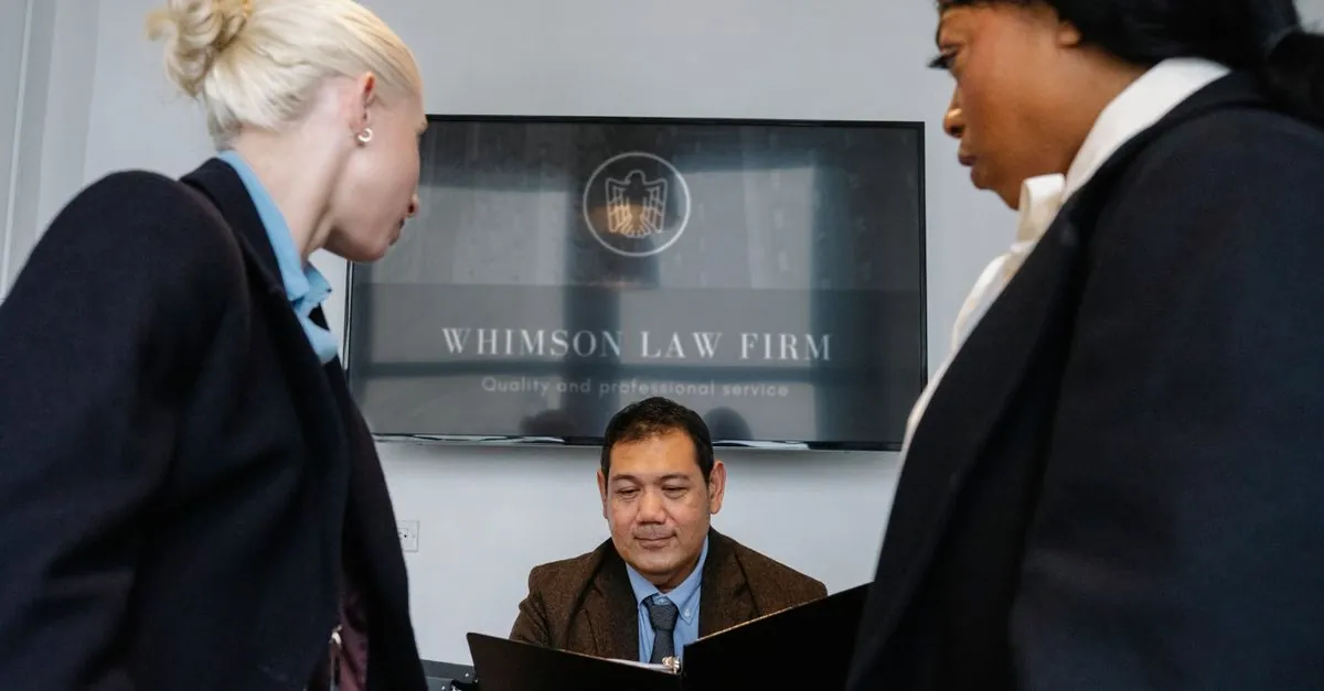 Legal and business professionals meeting around a conference table in a modern office.